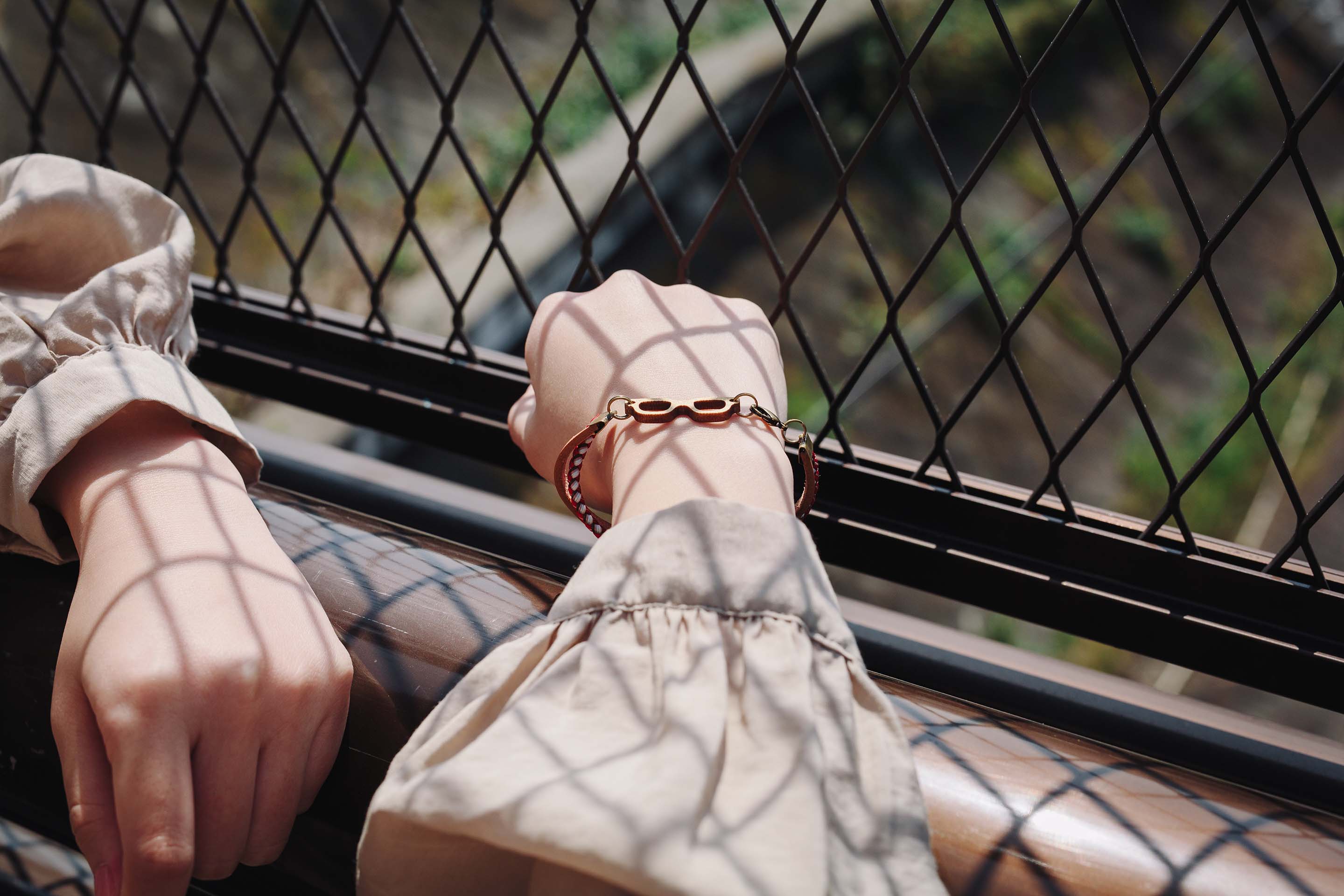 本革と組紐のブレスレットをつけた女性の手