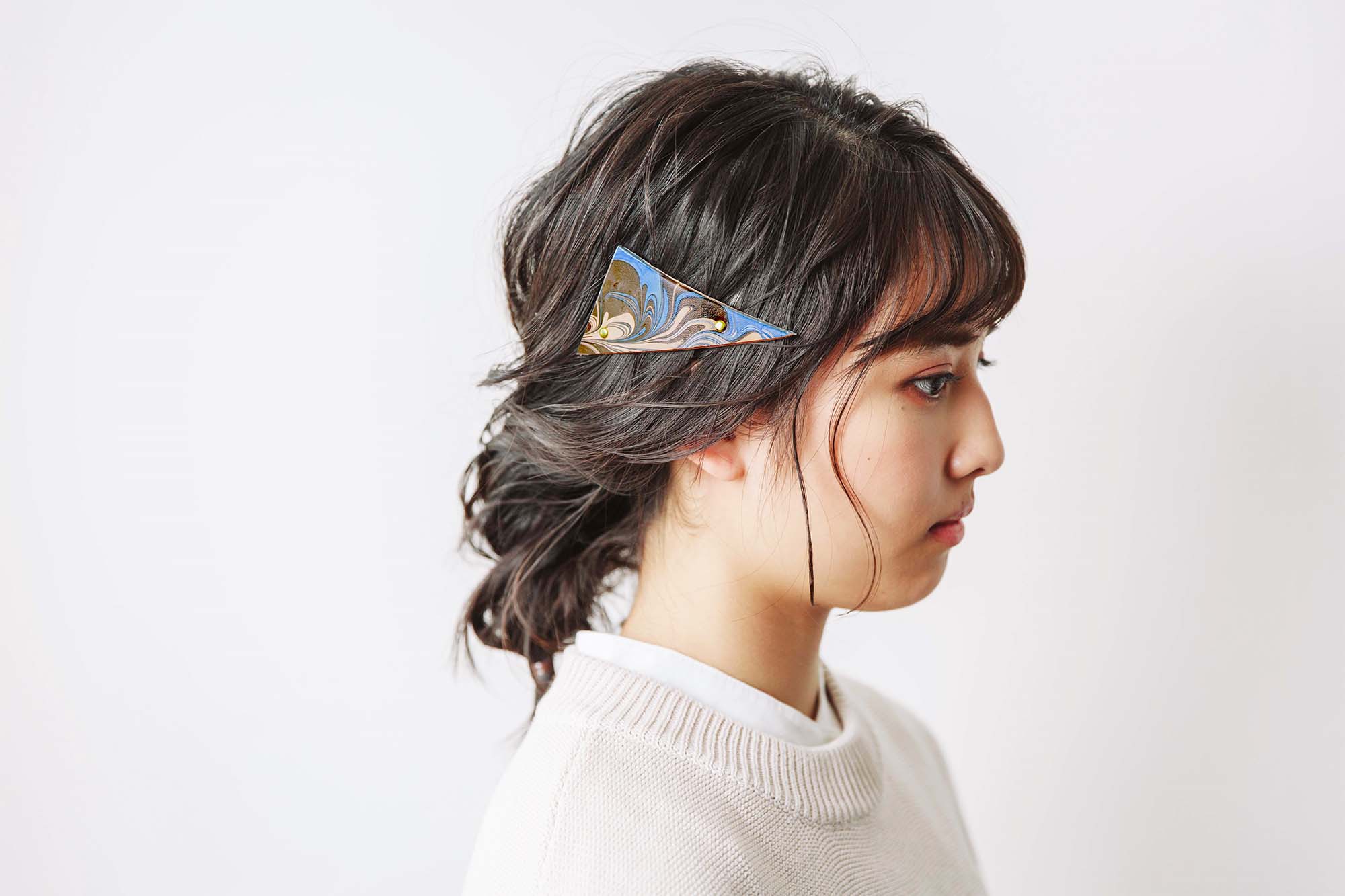 本革のマーブリングバレッタをつけた女性