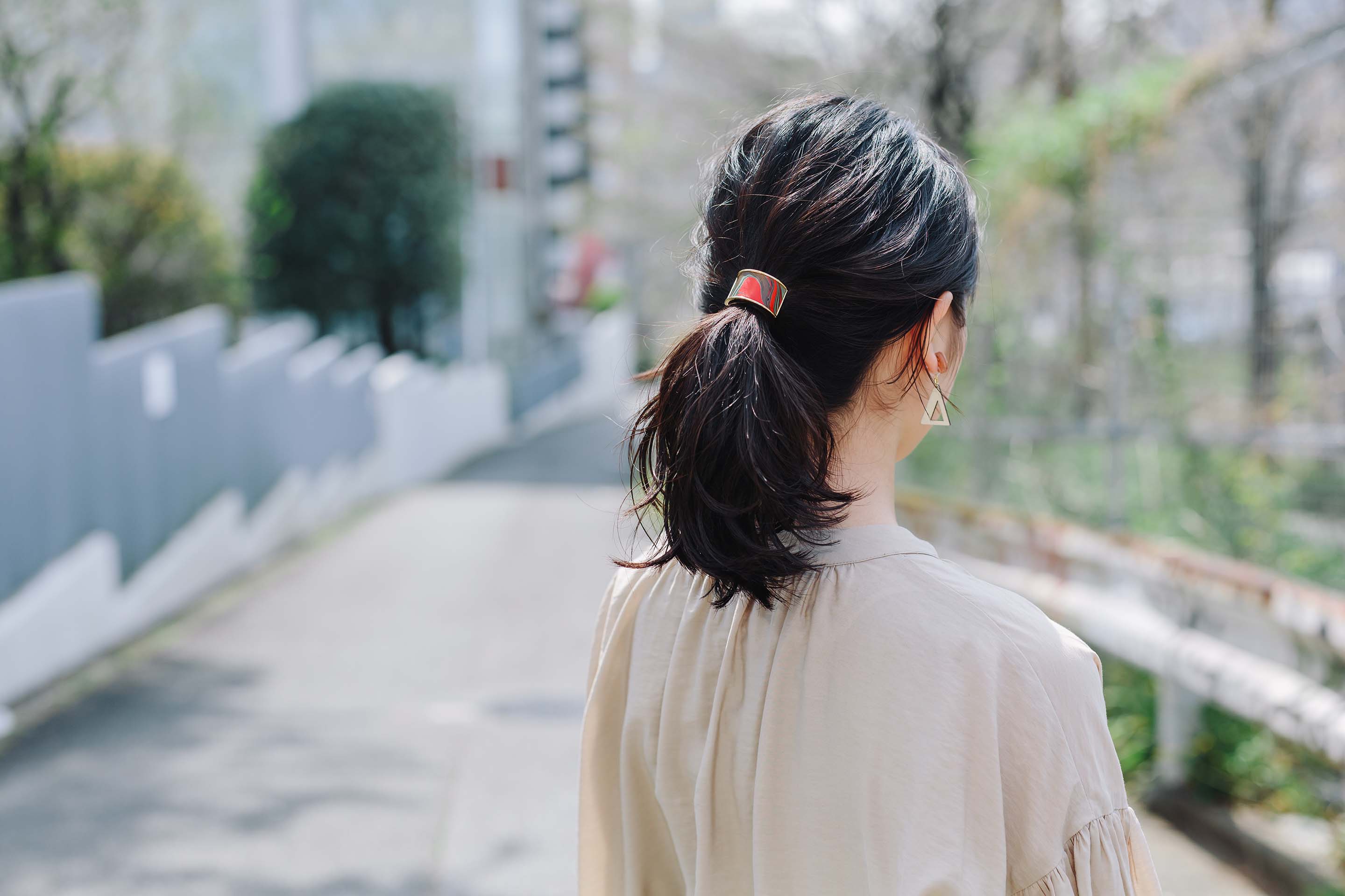 本革のマーブリングポニーフックをつけた女性の後ろ姿