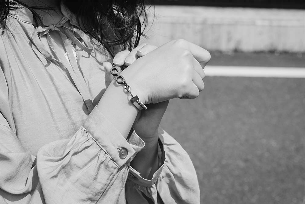 本革と組紐のブレスレットをつけた手元のモノクロ写真